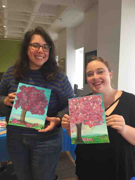 Member's of BDT's Employee Resource Group, LGBDTQ, holding paintings